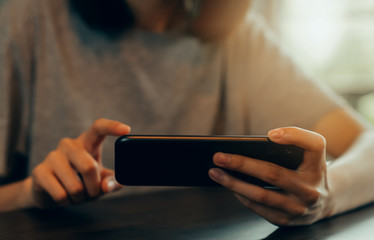 Closeup of young woman hand holding smartphone and chatting with friends at social network.