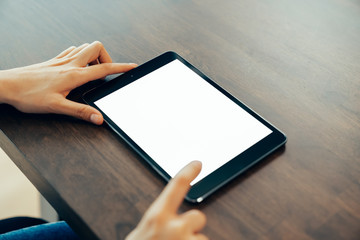 Closeup of woman hand holding digital tablet on the table and the screen is blank.