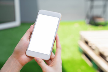 Mock up of woman hand holding smartphone and touching blank screen.