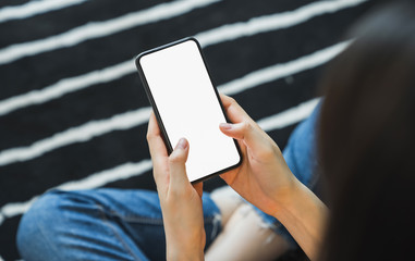 Woman hand holding smartphone and touching blank screen. Mockup of advertisement.