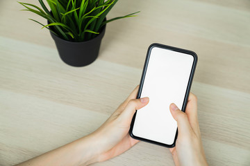 Woman hand holding smartphone and touching blank screen. Mockup of advertisement.