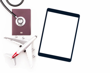 Trip, Travel and insurance concept. Mockup image of Black digital tablet with blank white screen, passport,medical stethoscope and plane model on white background.  clipping path and copy space