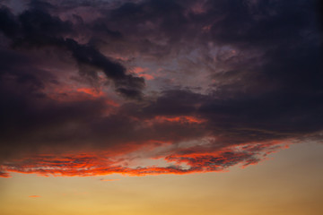 Black thunderclouds at sunset. Bright orange sunset and dark clouds. Storm sky