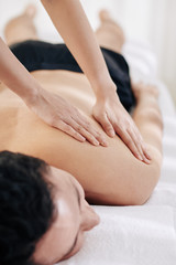 Obraz na płótnie Canvas Close-up image of masseuse using fanning technique when massaging back of client