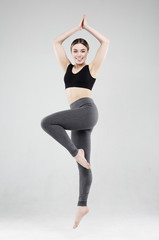 Fit and healthy woman. Happy fitness woman in sportwear jumping over white studio background.