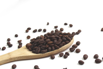 Wooden spoon with coffee grains on a white background
