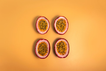 Top down view Cut half passion fruit (maracuja) with plain yellow orange color background.
