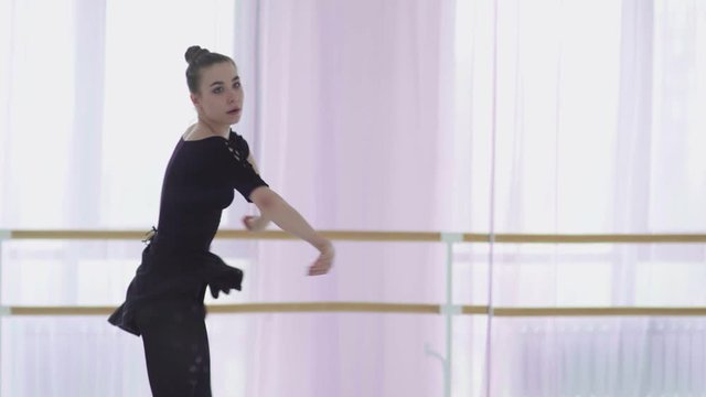 Active cute young ballerina enthusiastically dances ballet
