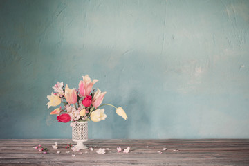 bouquet of spring flowers on background old blue wall