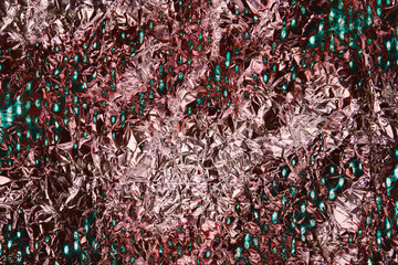 Foil aluminum crushed texture. Metal material background. Gold grunge decoration. Material pattern. Crinkle pink ang green chrome paper. Fabric shine sheet. Copyspace for text