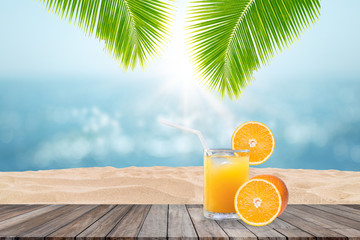 Summer Vacation Concept : Welcome drink orange juice punch put on wooden table with blue water and seascape view in background.
