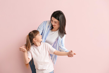 Happy woman with little adopted girl on color background