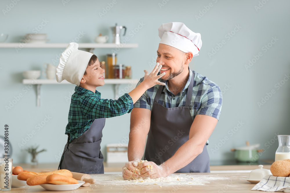 Poster Father and his little son cooking in kitchen