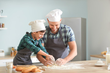 Father and his little son cooking in kitchen