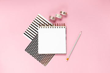 Notepad and notebooks with stationery. Golden, white, pink and black stationery back to school concept. Top horizontal view copyspace