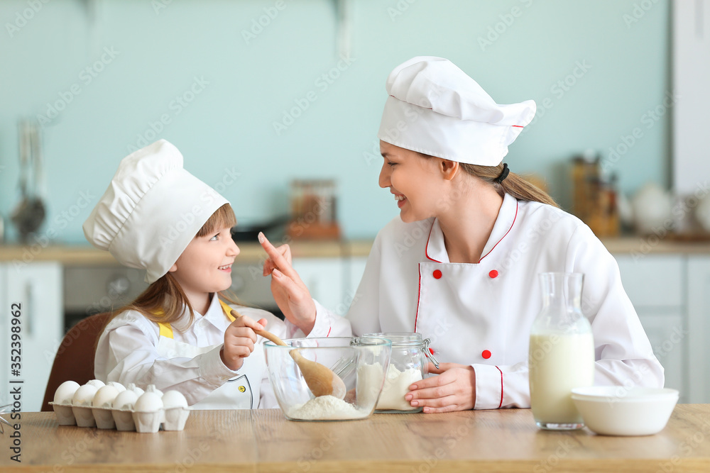 Canvas Prints female chef and her little daughter cooking in kitchen