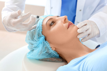 Obraz na płótnie Canvas Woman receiving filler injection in beauty salon
