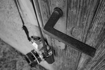 film camera hanging from the door of an abandoned house