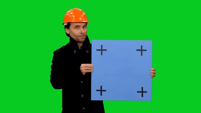 Constructor builder in hard hat telling the workplan with blue blank board on green screen background, Chroma key 4k footage