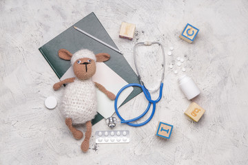 Stethoscope, stationery, pills and toys on white background