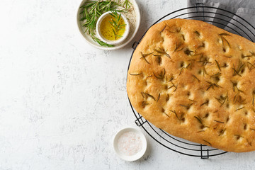 Focaccia, pizza, italian flat bread with rosemary and olive oil on grid