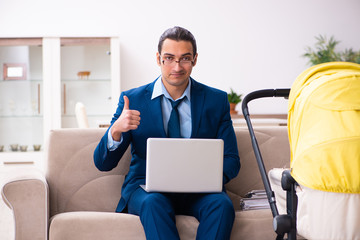 Young businessman looking after newborn at home