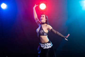 Young woman dancing in Tribal Fusion style. Belly dance on the stage.