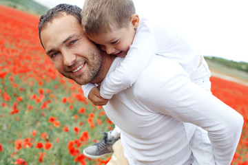 A man and a child are resting in nature. Father and son have fun in the field.