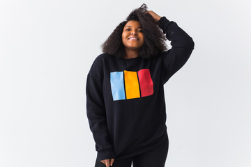 Beautiful African American woman posing in black sweatshirt on a white background. Street fashion...
