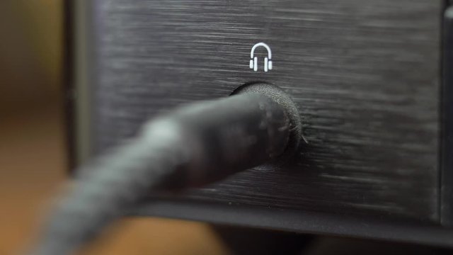 Connecting Headphones to Headphone Jack Slot in Stereo Set Close-Up