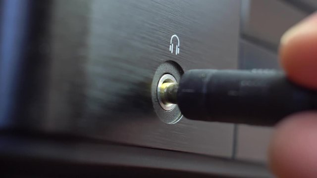 Connecting Headphones to Headphone Jack Slot in Stereo Set Close-Up