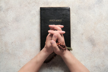 Religious man praying at table, top view