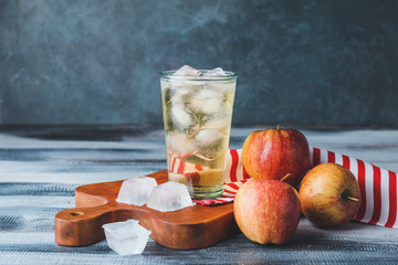 Glass of cold apple cider on table