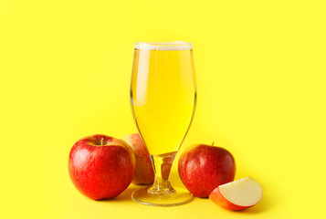 Glass of apple cider on color background