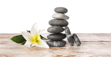Fototapeta na wymiar Zen stones and flower on table against white background