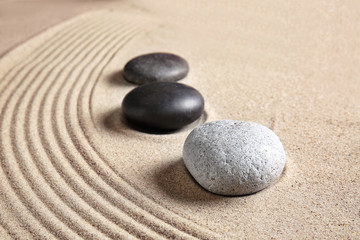 Fototapeta na wymiar Stones on sand with lines. Zen concept