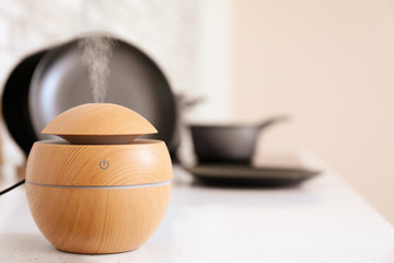 Aroma oil diffuser on table in kitchen