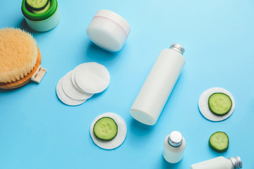 Composition with cucumber and cosmetics on color background