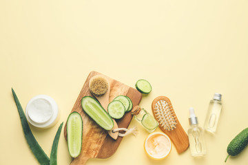 Composition with cucumber and cosmetics on color background