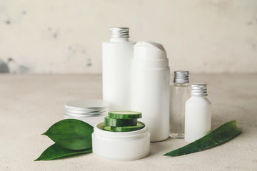 Cosmetics with cucumber extract on table