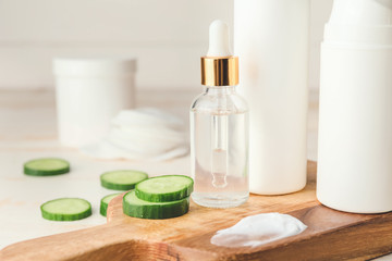 Cosmetics with cucumber extract on table