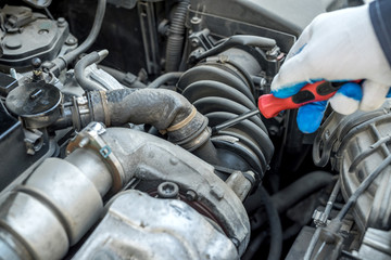 mechanic's hand with screwdriver repair or check car  in garage