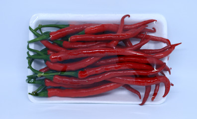 Chili peppers In a transparent plastic on white background.