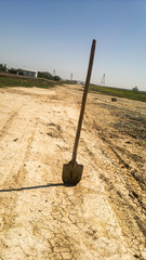 Lonely shovel stands in a field near the road