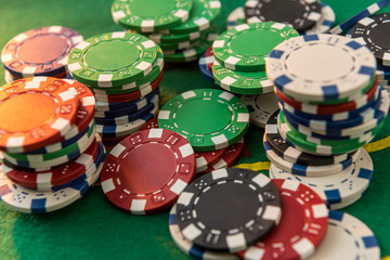 Many different cost poker chips on play table. large game bet on the green cloth field