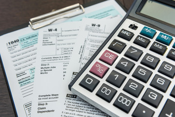 Fototapeta na wymiar Finance income, time fot tax calculator and pen lying on federal form