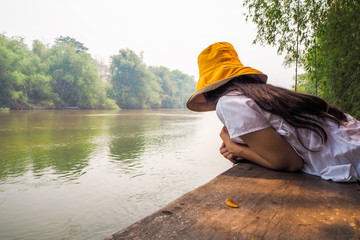 Woman wearing a yellow hat on the waterfront