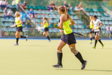 Female field hockey player in the game - Powered by Adobe