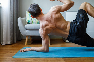 Fototapeta na wymiar Young man practicing yoga at home on quarantine