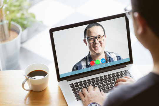 Back view of businessman speak talk on video call on computer colleagues